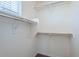 A spacious walk-in closet with white shelving and neutral walls at 26505 N Babbling Brook Dr, Phoenix, AZ 85083