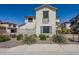 View of a two-story home with neutral stucco, grey shutters, desert landscaping, and a balcony at 26505 N Babbling Brook Dr, Phoenix, AZ 85083