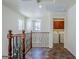 Hallway with laundry room access, decorative railing, and natural light from windows at 26505 N Babbling Brook Dr, Phoenix, AZ 85083