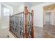 Upstairs hallway features tile flooring, decorative wrought iron railing, and natural light at 26505 N Babbling Brook Dr, Phoenix, AZ 85083