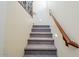 Carpeted staircase with wooden handrail and modern lighting at 26505 N Babbling Brook Dr, Phoenix, AZ 85083