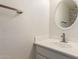 Bathroom featuring a white vanity, round mirror, and modern faucet, and textured wall at 2741 E San Tan St, Chandler, AZ 85225