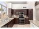 A well-lit kitchen featuring stainless steel appliances, granite countertops, and brown cabinets at 2741 E San Tan St, Chandler, AZ 85225