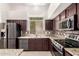 Kitchen with granite countertops, a mosaic backsplash, stainless steel appliances, and brown cabinets at 2741 E San Tan St, Chandler, AZ 85225