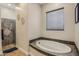 Bright bathroom featuring a sleek soaking tub and a glass-enclosed shower at 28156 N Edwards Rd, San Tan Valley, AZ 85143