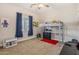 Bright bedroom includes a loft bed, a small table, and blue curtains at 28156 N Edwards Rd, San Tan Valley, AZ 85143