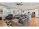 Open-concept living room showcasing hardwood floors, a large sectional sofa, and natural light at 28156 N Edwards Rd, San Tan Valley, AZ 85143