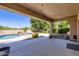 Inviting backyard with covered patio, lush landscaping, and a sparkling pool with waterfall at 28806 N 23Rd Ln, Phoenix, AZ 85085