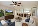 Open concept living area featuring a ceiling fan, media center, and adjacent desk space for working at 28806 N 23Rd Ln, Phoenix, AZ 85085