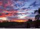 Dramatic desert sunset featuring a pool area with a waterfall at 28806 N 23Rd Ln, Phoenix, AZ 85085