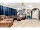 Comfortable living room with tile flooring, a ceiling fan, a plush sectional sofa, and an arched doorway at 2944 N Brighton --, Mesa, AZ 85207