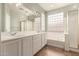 Bathroom with double sinks, a large mirror, soaking tub, and glass block window at 29919 N Little Leaf Dr, San Tan Valley, AZ 85143