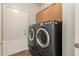 Laundry room with gray washer and dryer and storage cabinet at 29919 N Little Leaf Dr, San Tan Valley, AZ 85143