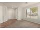 Bright living room featuring neutral carpet, tile flooring, a large window, and a coat closet at 29919 N Little Leaf Dr, San Tan Valley, AZ 85143