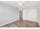 Bright bedroom features gray walls, wood-look floors, and closet with sliding doors at 3056 N 68Th Ln, Phoenix, AZ 85033