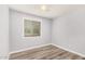 Bright bedroom featuring gray walls, wood-look floors, ceiling fan, and window with blinds at 3056 N 68Th Ln, Phoenix, AZ 85033