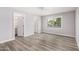 Bright bedroom featuring wood-look floors, neutral paint, and natural light from a window at 3056 N 68Th Ln, Phoenix, AZ 85033