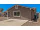 Side view of a single-story home, showcasing the desert landscape and paved area at 3056 N 68Th Ln, Phoenix, AZ 85033
