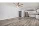 Open-concept living space with gray laminate floors and a view of the bright, modern kitchen at 3056 N 68Th Ln, Phoenix, AZ 85033