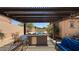Outdoor kitchen and dining area with a view of the backyard pool at 3063 N Heritage St, Buckeye, AZ 85396