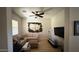 Bonus room with a ceiling fan and a unique wooden wall art piece, and a tan sofa at 3063 N Heritage St, Buckeye, AZ 85396
