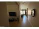 Hallway leading into living room featuring tile floors, and a wall-mounted television at 3063 N Heritage St, Buckeye, AZ 85396