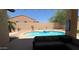 Backyard pool surrounded by desert landscaping, seating, and a privacy fence at 3063 N Heritage St, Buckeye, AZ 85396