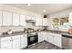 Bright kitchen featuring stainless steel appliances, white cabinets, and a modern sink with a view at 3114 W Villa Maria Dr, Phoenix, AZ 85053
