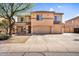 Two-story home featuring a three-car garage and a desert-landscaped front yard under a sunny blue sky at 3423 E Superior Rd, San Tan Valley, AZ 85143