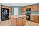Well-equipped kitchen with wood cabinets, an island, and stainless-steel appliances against a blue painted wall at 3423 E Superior Rd, San Tan Valley, AZ 85143