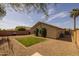 The backyard is xeriscaped with gravel, has a manicured lawn, and is bordered by a privacy fence at 3905 E Derringer Way, Gilbert, AZ 85297