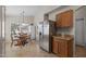 Eat-in kitchen with stainless steel refrigerator, wood cabinetry, and a cozy dining area at 3905 E Derringer Way, Gilbert, AZ 85297