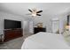 A spacious main bedroom with a bed, a TV, wooden dressers, and an ensuite bathroom at 3905 E Derringer Way, Gilbert, AZ 85297