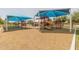 Community playground with slides, swings, and playground equipment all covered by shade canopies at 3905 E Derringer Way, Gilbert, AZ 85297