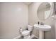 Clean powder room featuring a pedestal sink, round mirror, and neutral wall color at 3916 S 79Th Ln, Phoenix, AZ 85043