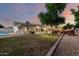 Expansive backyard featuring a pool, covered patio, well-kept lawn, and charming string lights for outdoor enjoyment at 4013 E Delta Cir, Mesa, AZ 85206