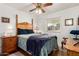 Cozy bedroom featuring a window, wood floors, and a ceiling fan with light at 4013 E Delta Cir, Mesa, AZ 85206