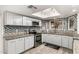 Updated kitchen featuring granite countertops, a stylish mosaic backsplash, stainless steel appliances, and natural light from the skylight at 4013 E Delta Cir, Mesa, AZ 85206