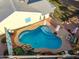 Aerial view of a kidney-shaped pool with an attached patio, various seating options, and custom rock features at 4013 E Delta Cir, Mesa, AZ 85206