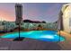 Backyard swimming pool with ambient lighting and a decorative rock waterfall feature, perfect for evening relaxation at 4013 E Delta Cir, Mesa, AZ 85206