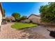 Well-maintained backyard with lush green lawn, a brick paver patio, and mature trees under a clear blue sky at 4037 E Elmwood St, Mesa, AZ 85205