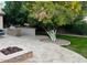 Outdoor kitchen, seating area, firepit, and tree add to the appeal of the backyard space at 4037 E Elmwood St, Mesa, AZ 85205