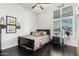 Well-lit bedroom with dark hardwood floors, decorative accents, and a large window with shutter blinds at 4037 E Elmwood St, Mesa, AZ 85205