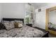 Cozy bedroom features a patterned bedspread, a bedside table, and a window with shutter blinds for privacy at 4037 E Elmwood St, Mesa, AZ 85205