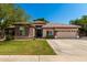 Charming single-story home boasts a lush lawn and a two-car garage with mature landscaping at 4037 E Elmwood St, Mesa, AZ 85205