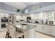 Bright kitchen with vaulted ceiling and white cabinets, complete with island seating and stainless steel appliances at 4037 E Elmwood St, Mesa, AZ 85205