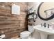 Stylish powder room featuring a wood accent wall, floating shelves, and modern fixtures at 4037 E Elmwood St, Mesa, AZ 85205