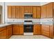 Kitchen featuring wood cabinets, granite countertops, and stainless steel appliances at 4701 W Fallen Leaf Ln, Glendale, AZ 85310