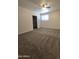Carpeted bedroom features a ceiling fan, natural light and closet for organized storage at 4911 W Merrell St, Phoenix, AZ 85031