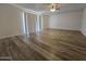 Spacious living room featuring sleek wood flooring and a modern ceiling fan at 4911 W Merrell St, Phoenix, AZ 85031